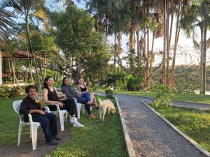 grupa ludzi siedzących na krześle z psem w obiekcie Hostel Lodge la Herradura w San José Del Guaviare