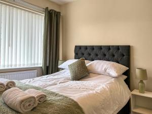 um quarto com uma cama grande e toalhas em Harris House em Staveley