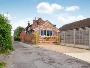 a brick house with a gate and a fence at Victory Hall Cottage in Spilsby