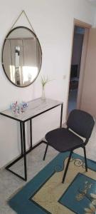 um espelho e uma cadeira num quarto em DAR EL3EZ em Sicca Veneria