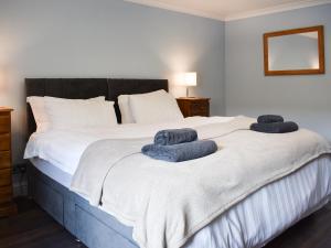 a bedroom with a bed with two towels on it at The Mews in Uldale