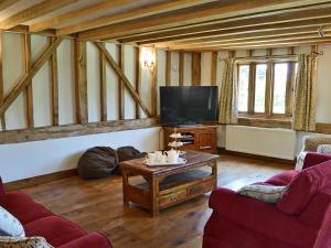 a living room with a tv and a coffee table at Romden Barn in Smarden