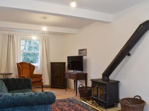- un salon avec un poêle à bois et un canapé dans l'établissement West End Farm, à Heathfield