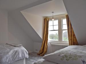 - une chambre mansardée avec un lit et une fenêtre dans l'établissement West End Farm, à Heathfield