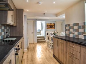 a kitchen with wooden cabinets and a dining room at The Beach House in Ramsgate