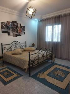 a bedroom with a bed with two rugs in it at DAR EL3EZ in Sicca Veneria