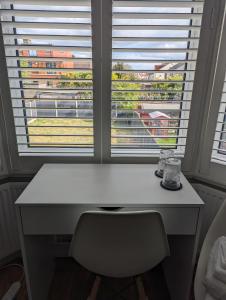 una scrivania di fronte a una finestra con vista di Luxury Hotel Rooms a Palmers Green