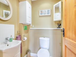 a bathroom with a white toilet and a sink at Oak Cottage in Ware