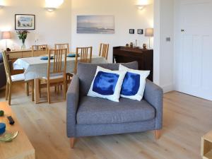 a living room with a chair and a dining room at Lyndale in Penzance
