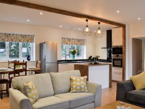 a living room with a couch and a kitchen at Spring Cottage in Kentisbury