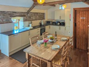 a kitchen with a wooden table with chairs and a dining room at Lord Mayors Barn in Alston
