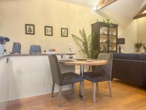 a table and chairs in a living room with a kitchen at Sykelands Cottage in Ravensworth