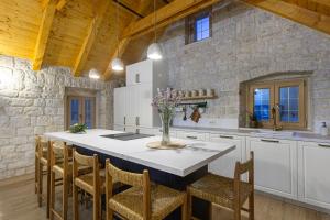 a kitchen with a large white kitchen island with chairs at House Marijeta and Tonka in Trogir