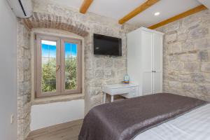 a bedroom with a bed and a tv on a wall at House Marijeta and Tonka in Trogir +30 photos