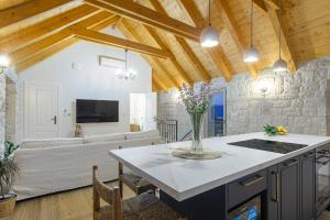 a kitchen and living room with wooden ceilings at House Marijeta and Tonka in Trogir