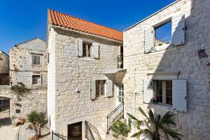 an old stone building with white shuttered windows at House Marijeta and Tonka in Trogir