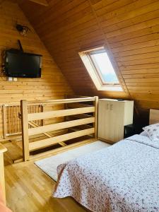a bedroom with a bed and a tv on the wall at Apartament Centrum Zakopane in Zakopane