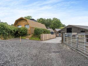 una casa de madera con una valla delante en The Honey Pod - Uk44780 en Hoel-galed