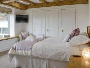 a bedroom with a large bed with white sheets and pillows at Coombe View in South Redworthy