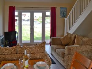 a living room with a couch and a table at Puffin Cottage in Wroxham