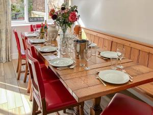 una larga mesa de madera con platos y copas de vino en The Townhouse en Wimborne Minster