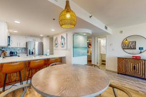 a kitchen with a wooden table and some chairs at One Seagrove Place 0206 in Santa Rosa Beach +25 photos
