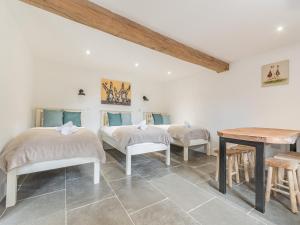 Cette chambre comprend 3 lits et une table. dans l'établissement The Red Rooster - Uk44440, à Arlingham