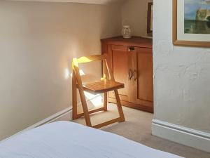 a wooden chair sitting in a room next to a bed at Market Place in Workington