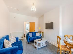 een woonkamer met een blauwe bank en een tafel bij Clifton House A - Uk42843 in Lytham St Annes