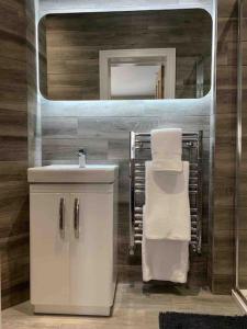 a bathroom with a sink and a mirror at Central Skipton - Devonshire Court Apartment 2 in Skipton