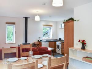a kitchen and living room with a table and a stove at Bridge Cottage in Earlston