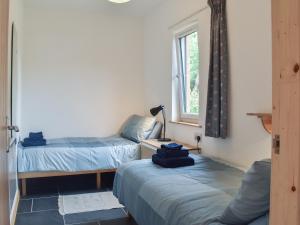 a room with two beds and a window at Bridge Cottage in Earlston