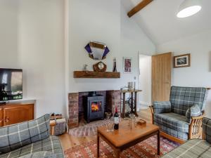 ein Wohnzimmer mit 2 Sofas und einem Kamin in der Unterkunft Barn Cottage in Falfield