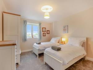 um quarto com 2 camas e uma janela em Barn Cottage em Falfield