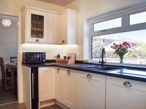 a kitchen with a sink and a microwave at Ballyholme in Skelton