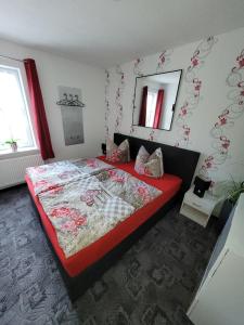 een slaapkamer met een groot bed en een spiegel bij Ferienwohnung 1 - a72143 in Wangerland