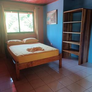een kleine slaapkamer met een bed en een raam bij Apartamento Il Delfino in Pavones