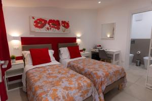 a bedroom with two beds with red pillows and a desk at Catania Castle affittacamere di Amato G in Catania