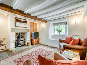 a living room with a couch and a tv at Lavender Cottage in Helmsley