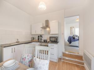 kuchnia z białymi szafkami oraz stołem i krzesłami w obiekcie Clifton Apartment - Uk42845 w mieście Lytham St Annes