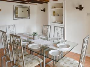 a dining room with a glass table and chairs at Findley Cottage 