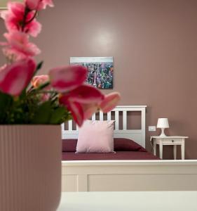- une chambre dotée d'un lit avec un oreiller et des fleurs roses dans l'établissement A & F Apartment, à Rome