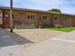 a brick building with a bench in front of it at Woodlands Dairy Cottage in Billingshurst