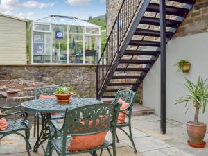 a patio with a table and chairs and a glass house at Alphin Apartment in Greenfield