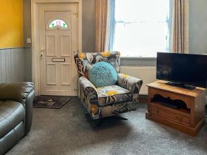 a living room with a chair and a television at Regent House in Leek