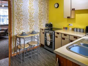 a small kitchen with a sink and a stove at Regent House in Leek