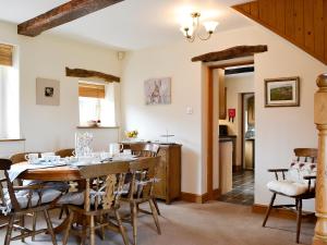 a kitchen and dining room with a table and chairs at Farm Cottage in Cleator