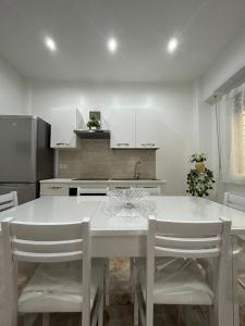 une cuisine avec une table blanche et des armoires blanches dans l'établissement A & F Apartment, à Rome
