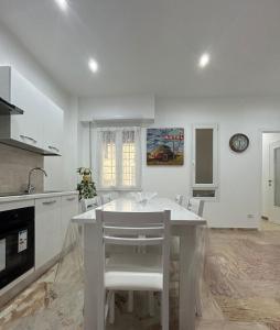 - une cuisine blanche avec une table et des chaises blanches dans l'établissement A & F Apartment, à Rome