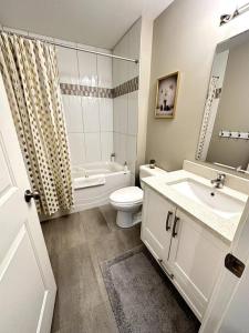 a bathroom with a sink and a toilet and a tub at Home Suite Home in Promontory Heights 1bdrm suite in Chilliwack